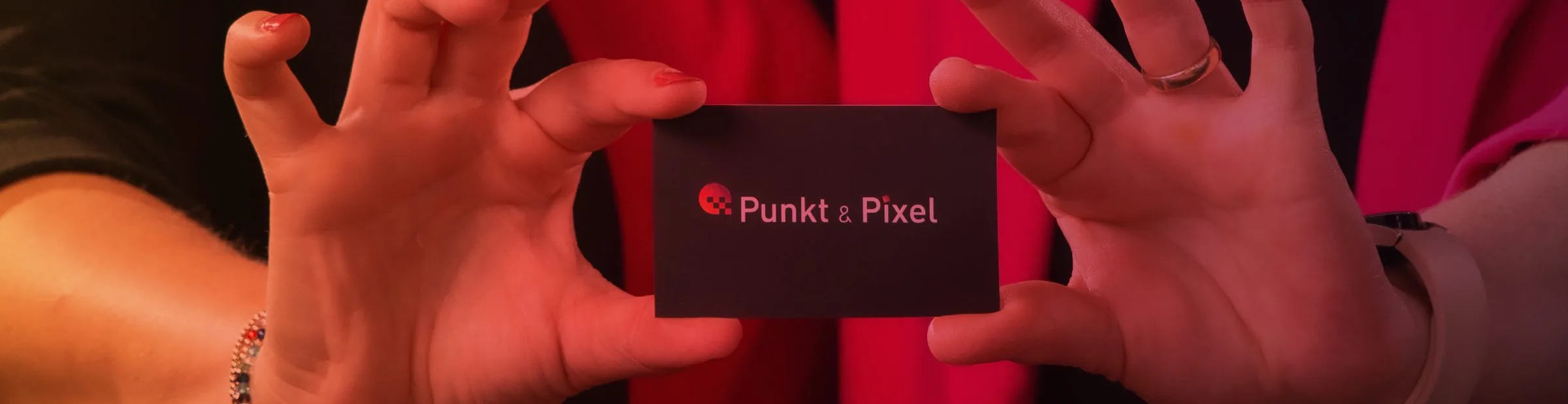 Visitenkarte im Corporate Design von Punkt & Pixel, in zwei Händen gehalten